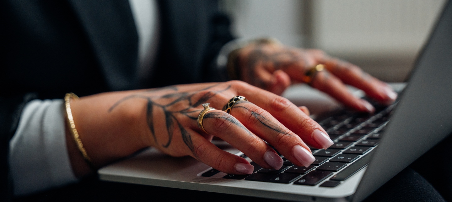 Goldene Ohrringe und eine Kette liegen auf einem weißen Untergrund